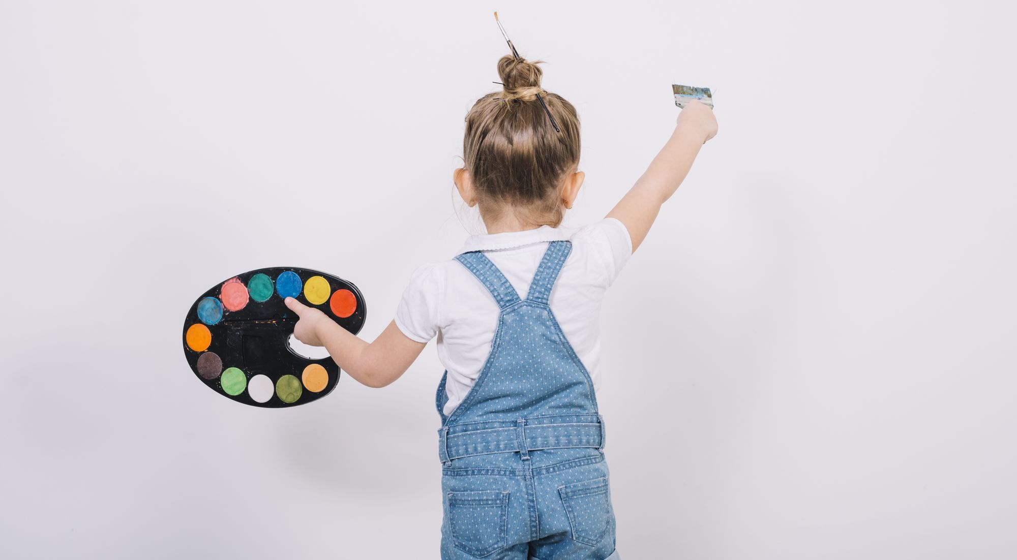 little-girl-painting-white-wall-with-brush